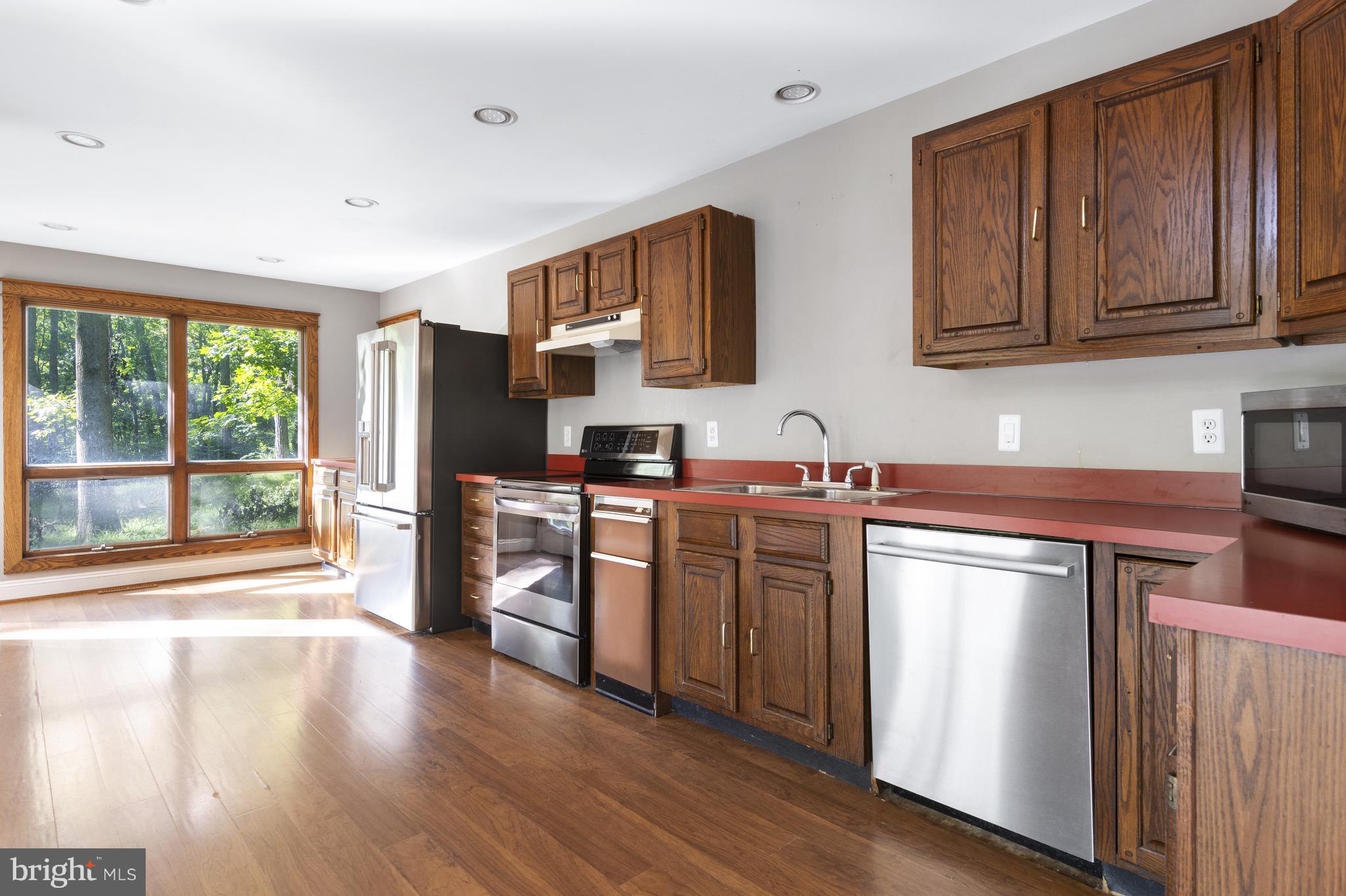 570 Chandler Mill Road Avondale, PA 19311 - Photo 17 of 41 a kitchen with stainless steel appliances granite countertop a refrigerator stove top oven and wooden floors