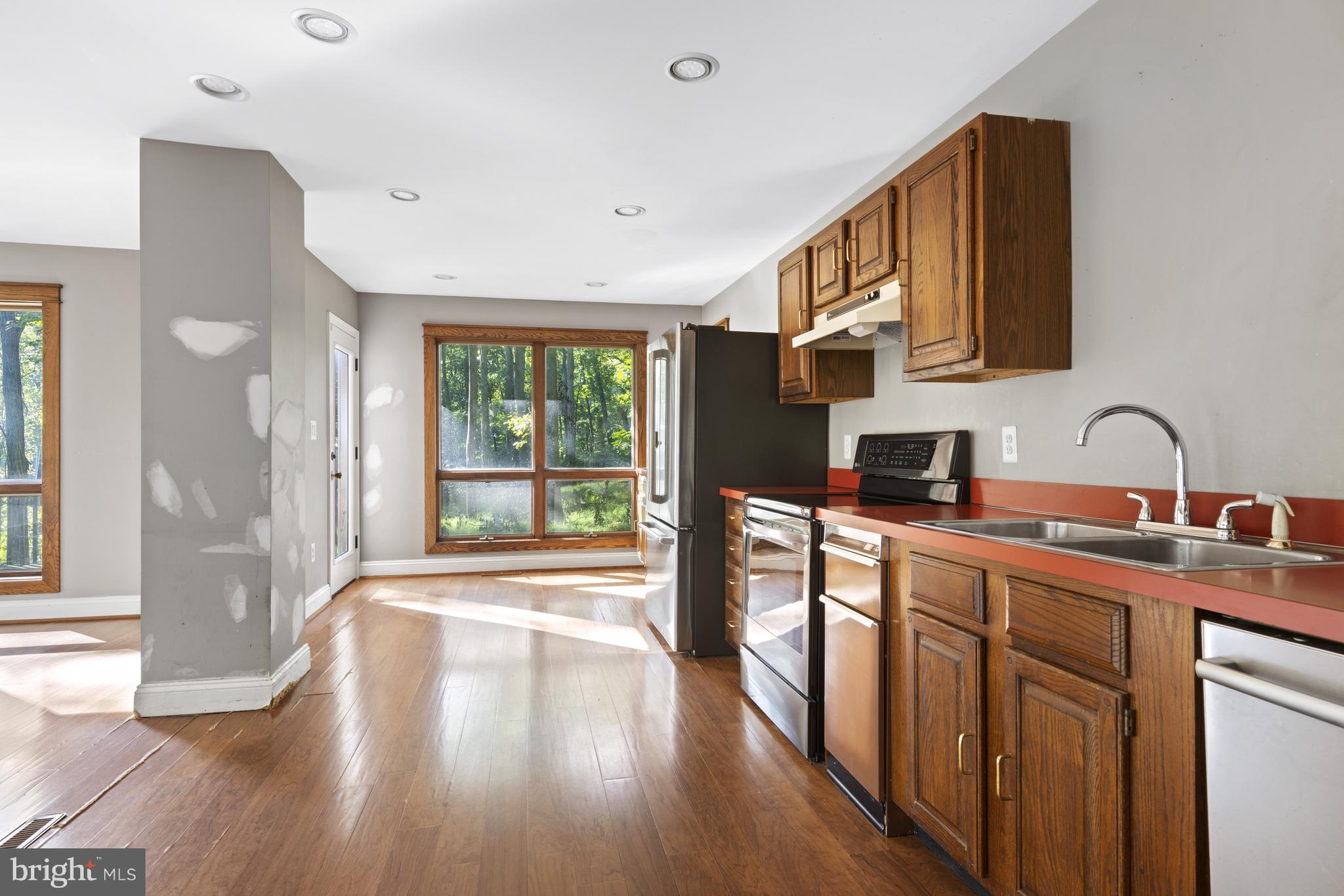 570 Chandler Mill Road Avondale, PA 19311 - Photo 18 of 41 a kitchen with stainless steel appliances granite countertop a sink and wooden floors