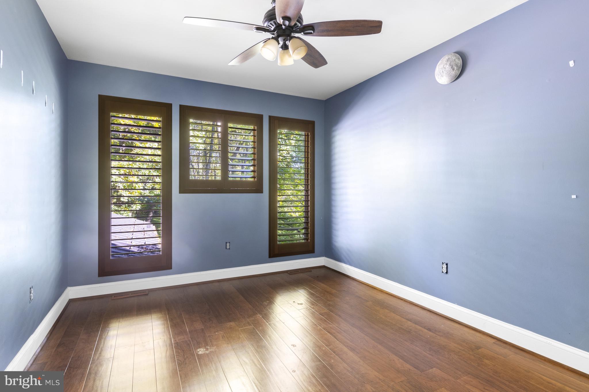 570 Chandler Mill Road Avondale, PA 19311 - Photo 33 of 41 an empty room with wooden floor fan and windows