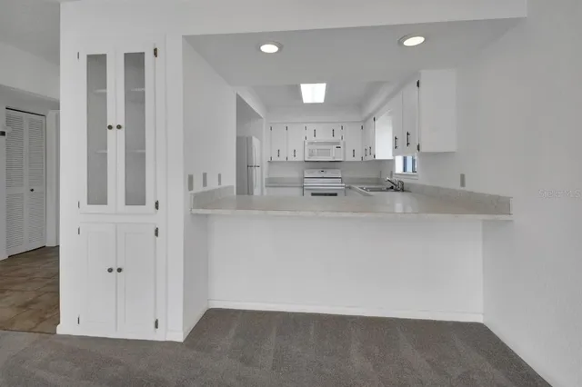 a view of a kitchen with white cabinets