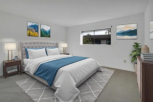 a bedroom with a bed and a painting on the wall