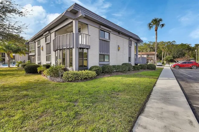 a view of a big house with a yard and plants