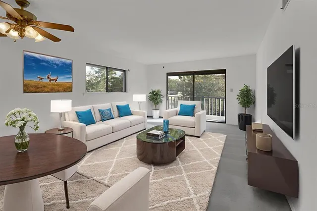 a living room with furniture a flat screen tv and a large window