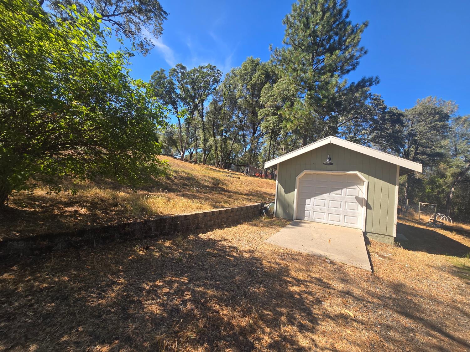 10601 Lime Kiln Road Grass Valley, CA 95949 - Photo 50 of 79 Detached garage with a paneled door, light green siding, and white trim