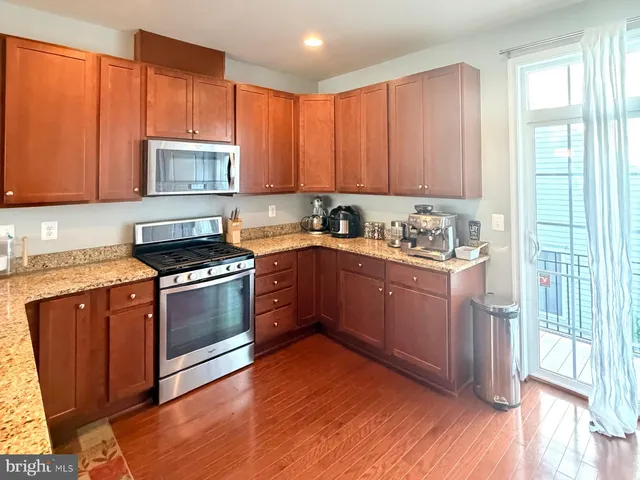 a kitchen with stainless steel appliances granite countertop a stove a sink dishwasher and a refrigerator