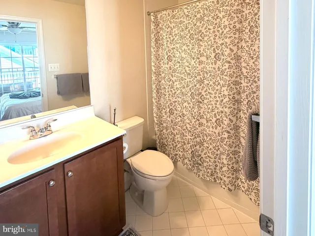 a bathroom with a granite countertop toilet and a sink