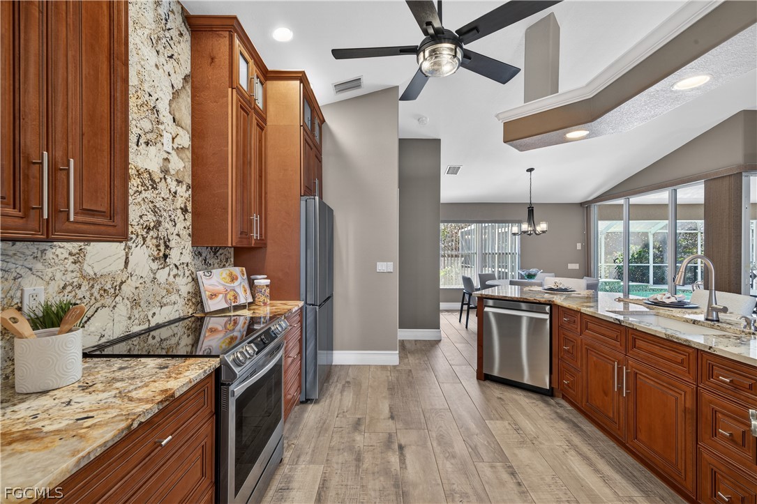 7407 Cobb Road Bokeelia, FL 33922 - Photo 13 of 41 a kitchen with stainless steel appliances granite countertop a sink stove and refrigerator