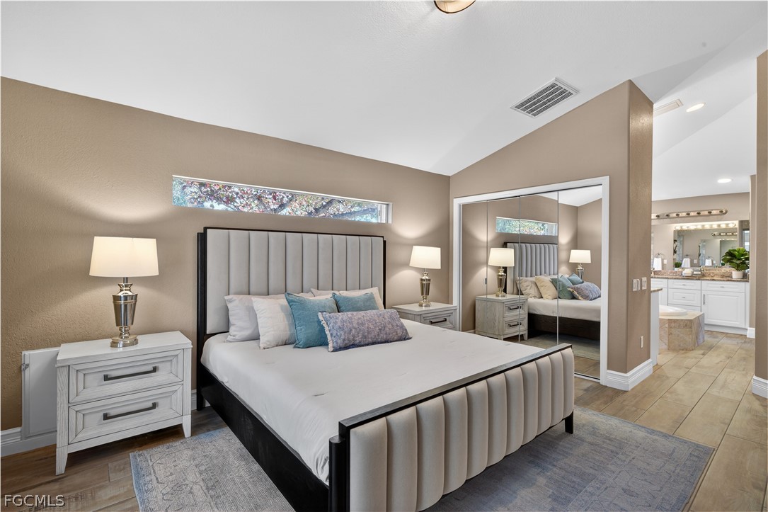 7407 Cobb Road Bokeelia, FL 33922 - Photo 20 of 41 a bedroom with a large bed and a chandelier