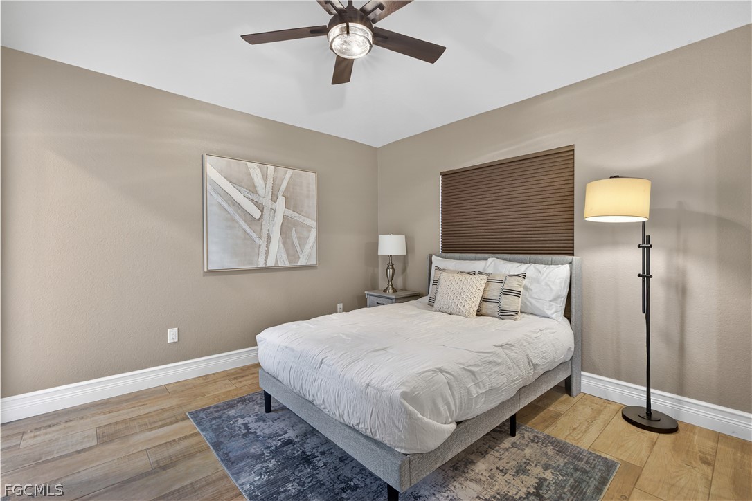 7407 Cobb Road Bokeelia, FL 33922 - Photo 23 of 41 a bedroom with a bed and a chandelier