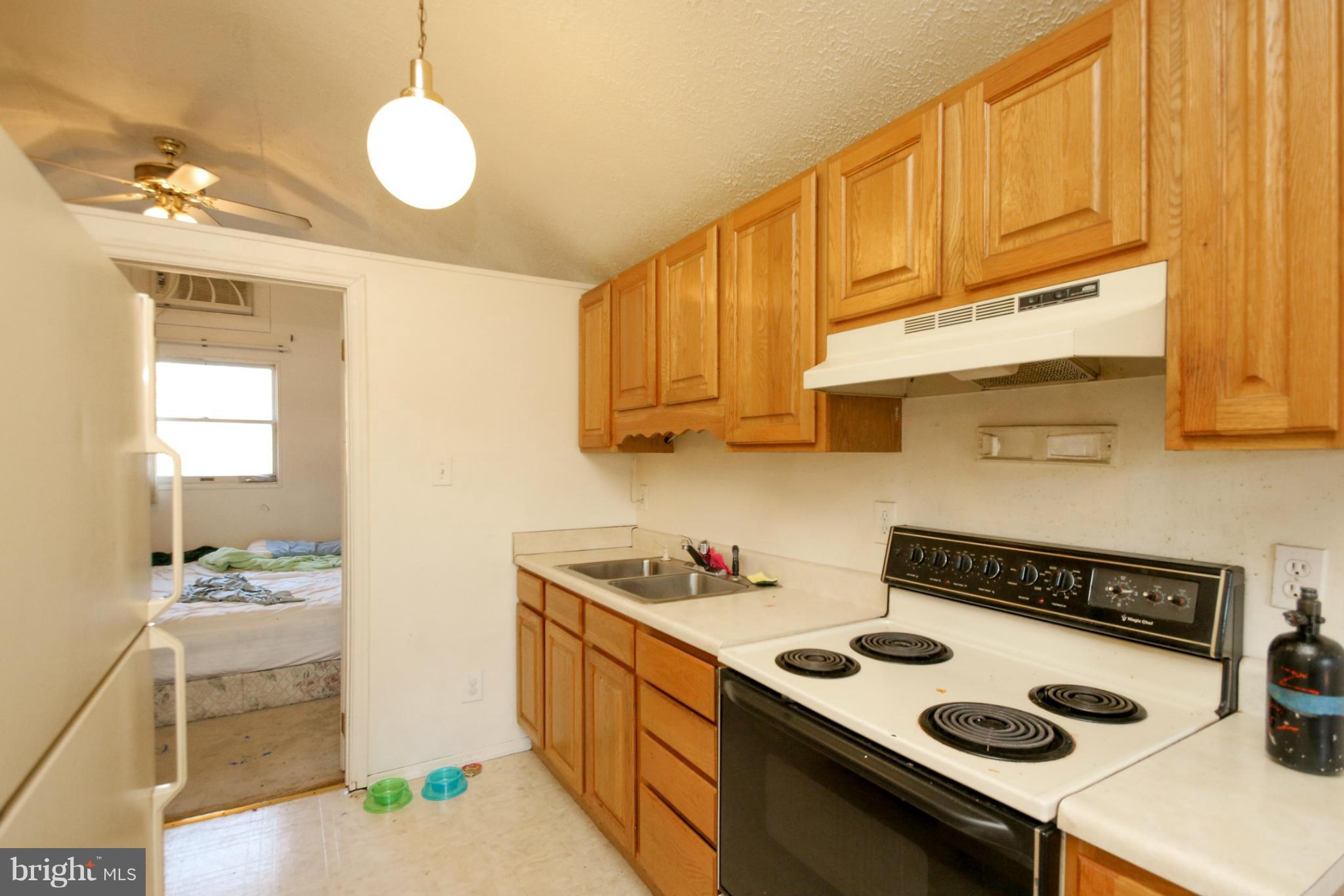 8183 Hog Neck Road Pasadena, MD 21122 - Photo 23 of 29 a kitchen with a sink a stove and cabinets