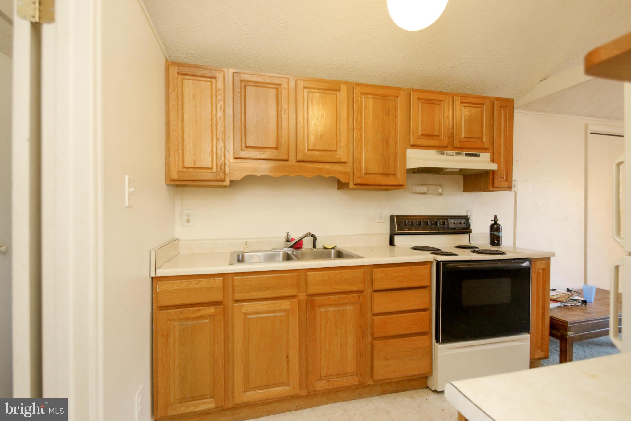 8183 Hog Neck Road Pasadena, MD 21122 - Photo 24 of 29 a kitchen with stainless steel appliances granite countertop a sink stove and cabinets