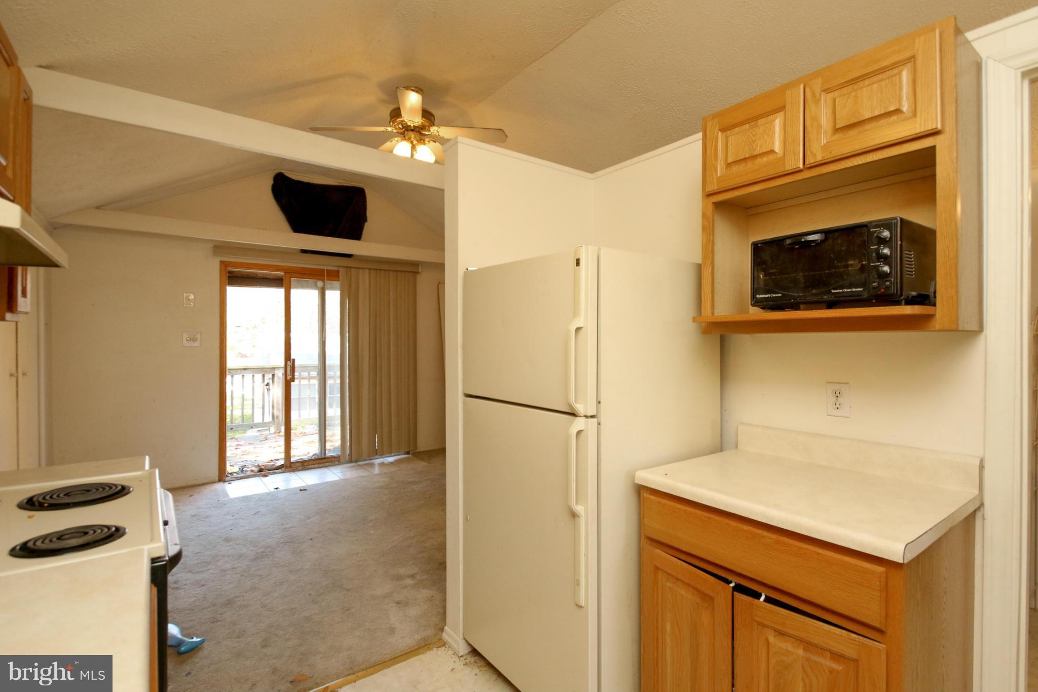 8183 Hog Neck Road Pasadena, MD 21122 - Photo 25 of 29 a kitchen with a refrigerator and a microwave