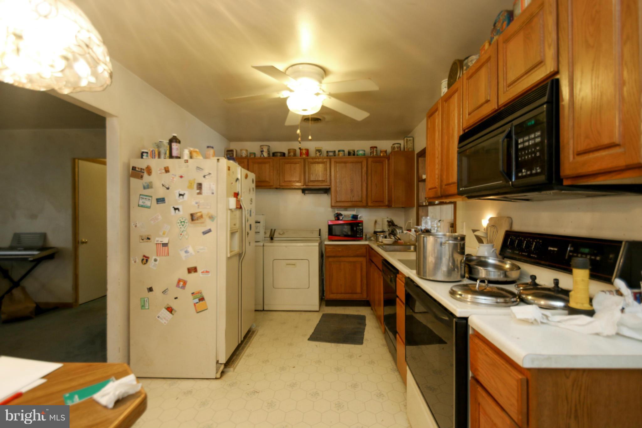 8183 Hog Neck Road Pasadena, MD 21122 - Photo 4 of 29 a kitchen with a refrigerator a stove top oven a sink and dishwasher