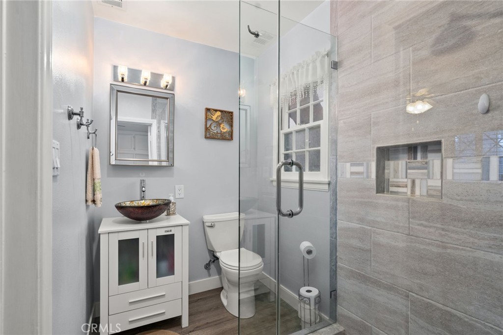 5180 Stonewood Drive Riverside, CA 92506 - Photo 22 of 31 a bathroom with a toilet a sink and shower