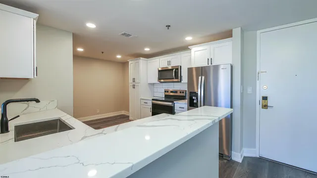 a kitchen with stainless steel appliances a refrigerator sink and microwave