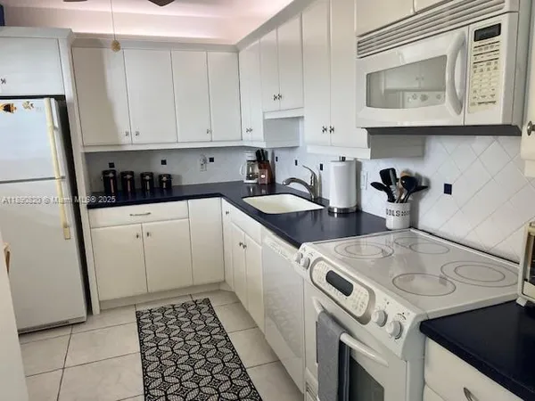 a kitchen with a sink a stove and cabinets