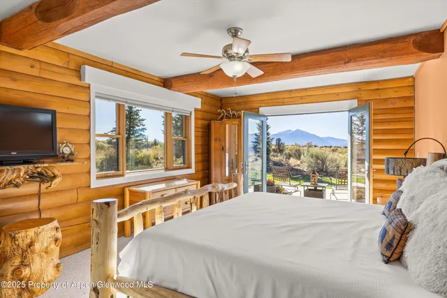 a bedroom with a bed and a flat tv screen on the dresser