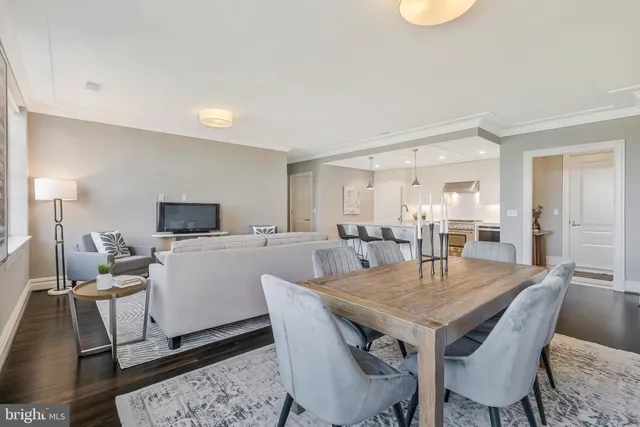 a kitchen with kitchen island granite countertop a dining table chairs and white cabinets