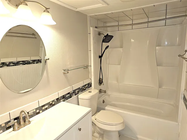 a bathroom with a sink a toilet and a mirror