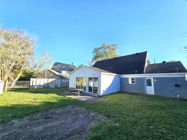 a front view of a house with a yard and large tree