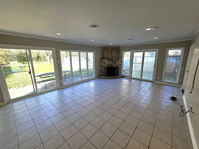 an empty room with fireplace and windows