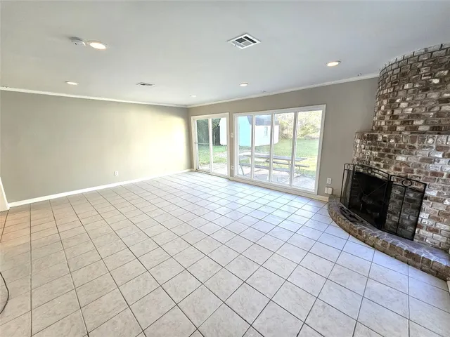 an empty room with windows and fireplace