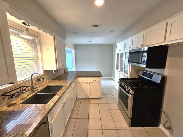 a kitchen with a sink stove and microwave