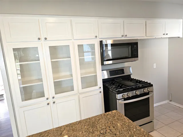 a kitchen with stainless steel appliances white cabinets and stove