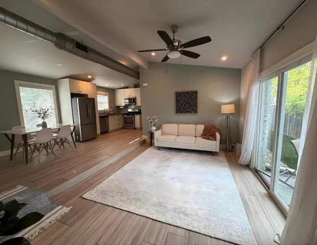 a living room with furniture and a wooden floor