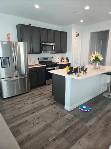 a kitchen with granite countertop a refrigerator stove and sink