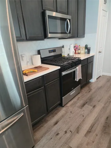 a kitchen with stainless steel appliances a stove microwave and sink