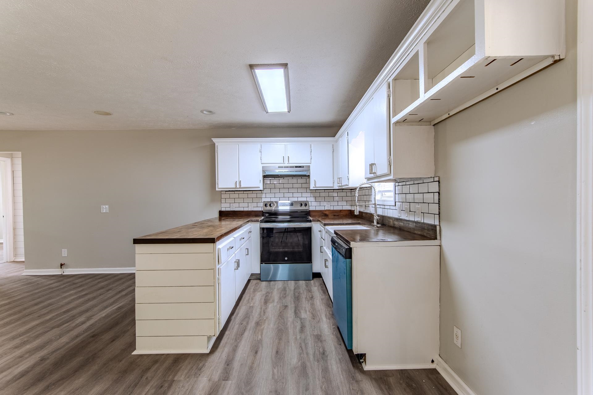 1633 Hardin Graveyard Road Adamsville, TN 38310 - Photo 15 of 33 a kitchen with a white cabinets and wooden floor