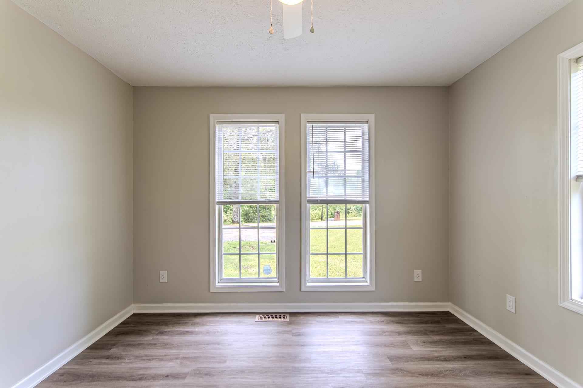 1633 Hardin Graveyard Road Adamsville, TN 38310 - Photo 21 of 33 an empty room with wooden floor and windows
