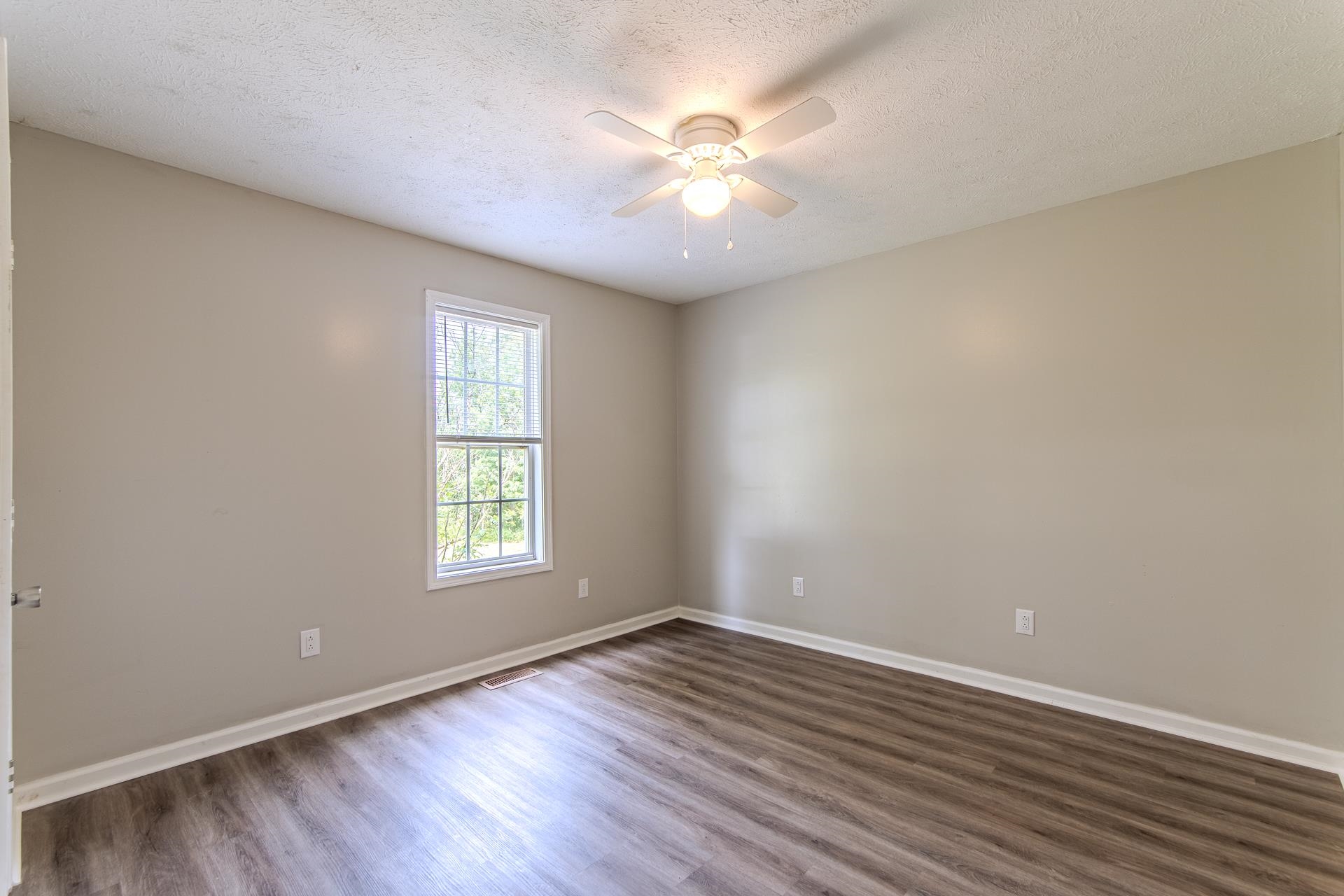 1633 Hardin Graveyard Road Adamsville, TN 38310 - Photo 25 of 33 an empty room with wooden floor and windows