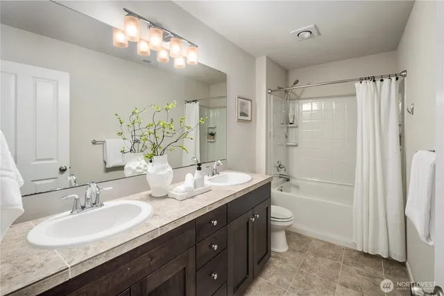 a bathroom with a double vanity sink mirror double and a bathtub