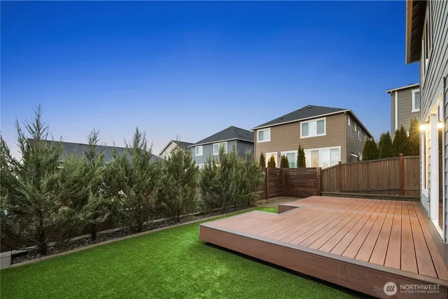 a view of an house with backyard and sitting area