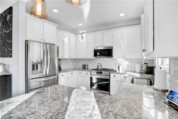 a kitchen with white cabinets and appliances