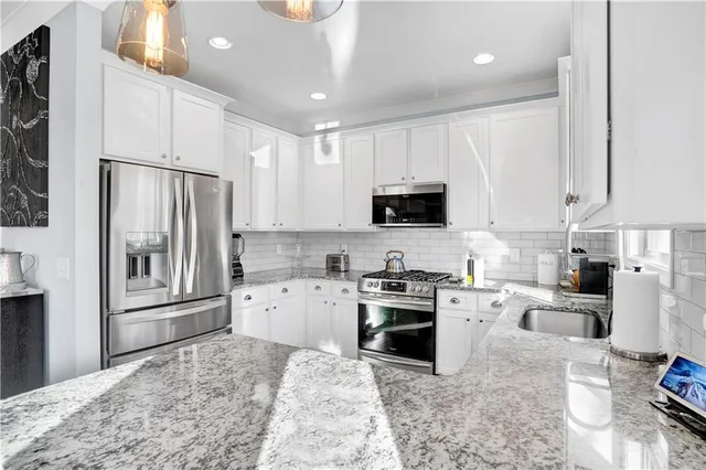 a kitchen with white cabinets and appliances