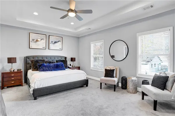 a bedroom with a bed a mirror and a flat tv screen on dresser