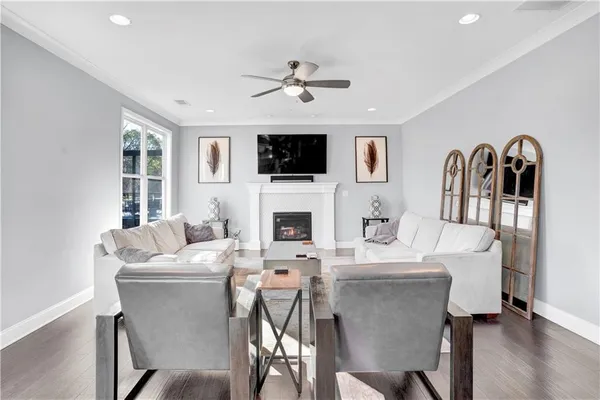 a living room with furniture kitchen view and a large window