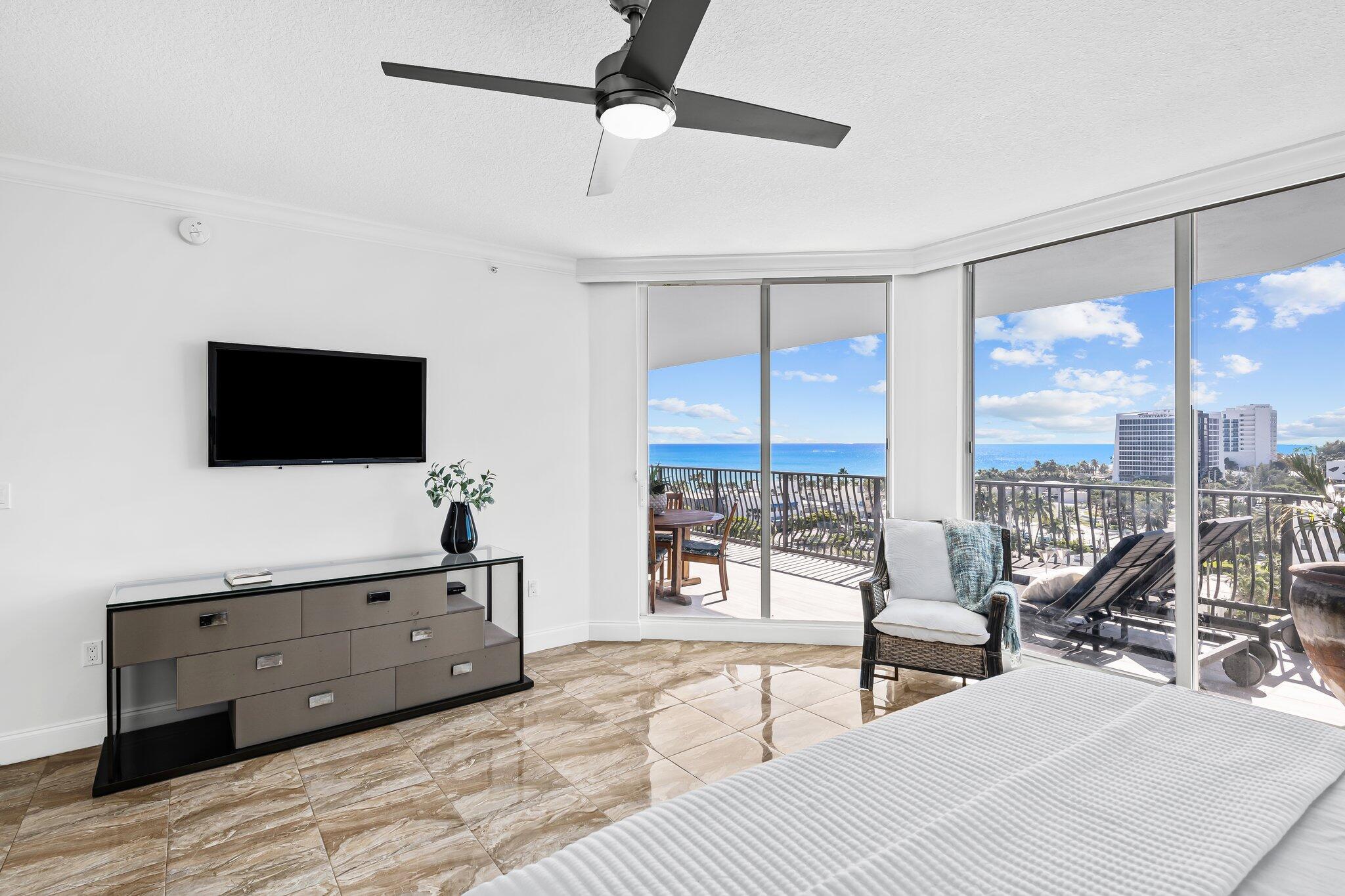 100 South Birch Road, Unit 1004 Fort Lauderdale, FL 33316 - Photo 12 of 39 a living room with furniture a flat screen tv and a floor to ceiling window