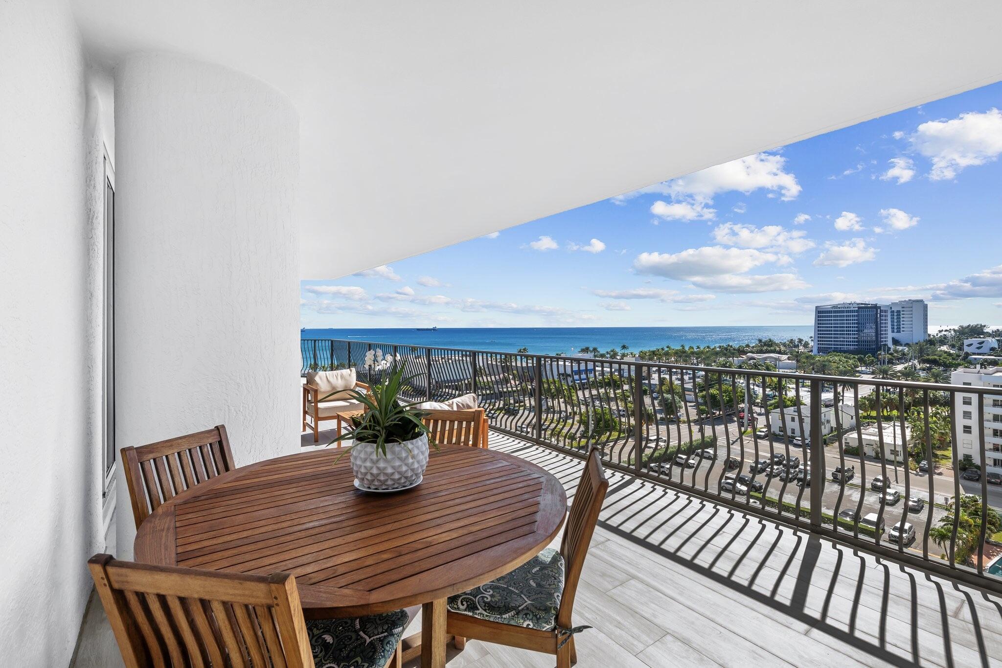 100 South Birch Road, Unit 1004 Fort Lauderdale, FL 33316 - Photo 10 of 39 a view of a balcony with a dining table and chairs with wooden floor
