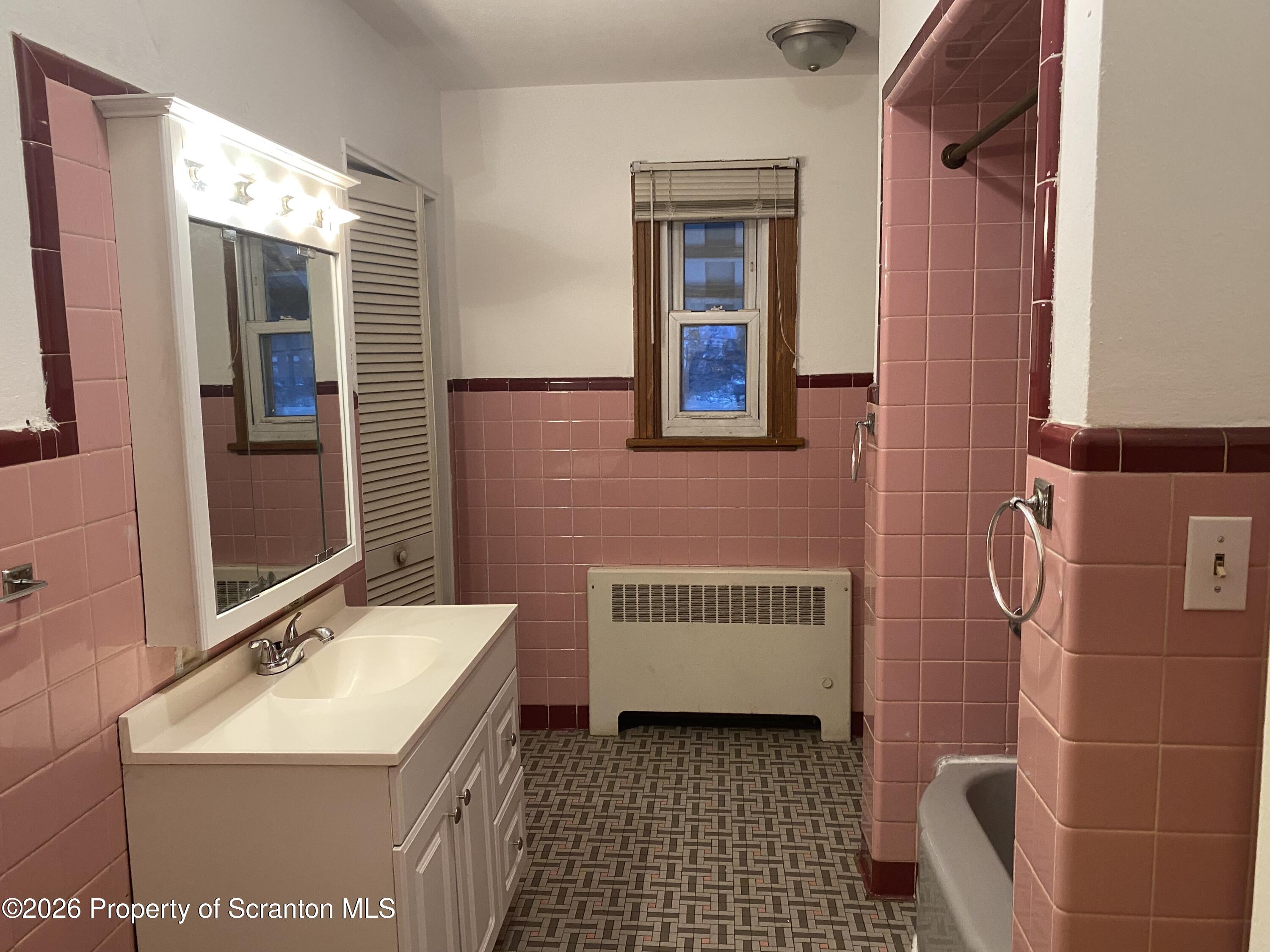 414 Orchard Street Scranton, PA 18505 - Photo 13 of 20 a bathroom with a sink a toilet and mirror