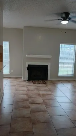 a view of empty room with fireplace and window