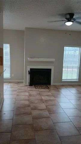 a view of empty room with fireplace and window