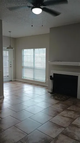an empty room with windows and fireplace