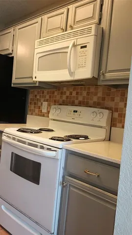 a stove top oven sitting inside of a kitchen
