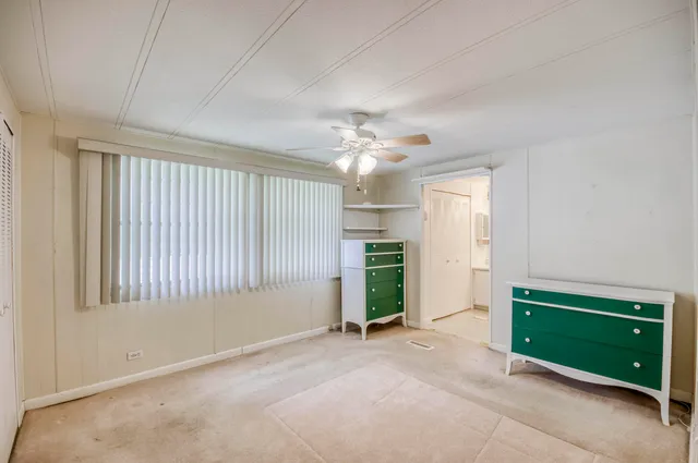 an empty room with windows and cabinet