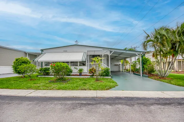a view of a house with a yard and potted plants
