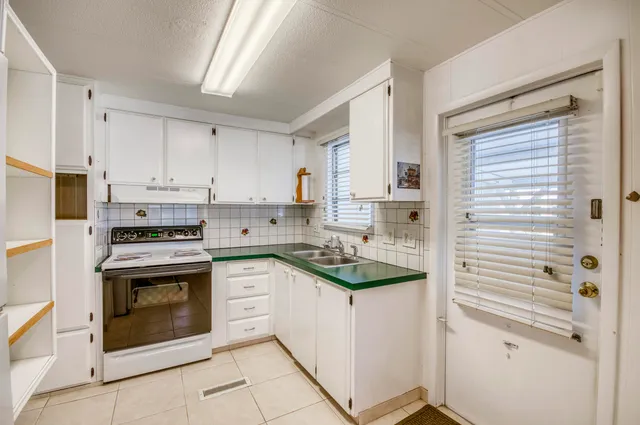 a kitchen with cabinets stainless steel appliances and sink